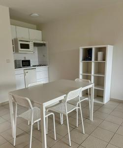 eine Küche mit einem Tisch und Stühlen im Zimmer in der Unterkunft Station 64 B1 Charleroi-Airport in Charleroi