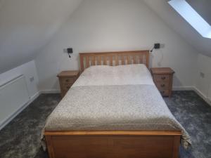 a bedroom with a bed and two night stands at Ole Butt Cottage in Cinderford