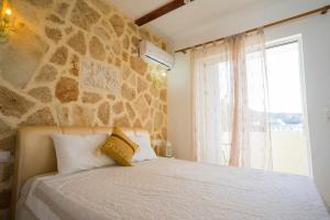 a bedroom with a bed with a stone wall at Farkia Exclusive Studios in Faliraki