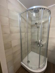 a shower with a glass door in a bathroom at apartment SPRING in Cēsis