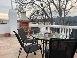 a table and chairs on a balcony with a fireplace at Vivienda Rural Casa Tavara in El Ojuelo