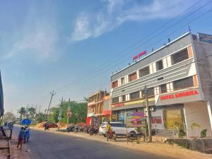 ein Gebäude an der Seite einer Straße mit Menschen auf Fahrrädern in der Unterkunft Hotel Shobha Forbesganj in Forbesganj