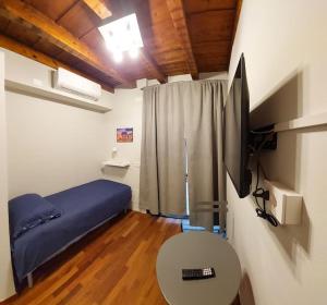 um quarto com uma cama, uma mesa e uma televisão em Appartamento in centro a Brescia:La Piccola House em Brescia