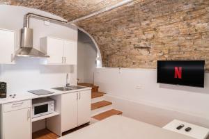 uma cozinha com uma televisão na parede de uma parede de tijolos em Appartamento in centro a Brescia:La Piccola House em Brescia