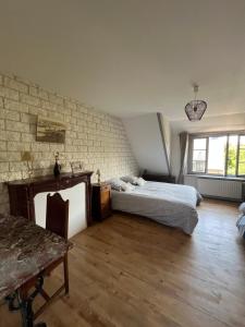 a bedroom with two beds and a brick wall at Chambres de Scavet in Tréguier