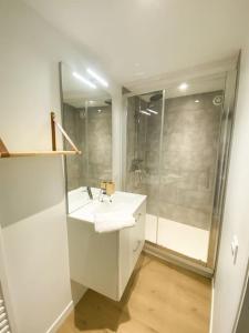 a white bathroom with a sink and a shower at NOUVEAU Maison Bourg Cournon 5 pers 2 chambres in Le Cendre