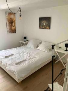 a white bed in a room with two tables at NOUVEAU Maison Bourg Cournon 5 pers 2 chambres in Le Cendre