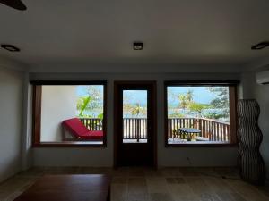 een woonkamer met 3 ramen en een rode bank bij Ciel y Miel in Colón