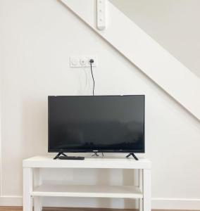 a tv sitting on a white table in a room at NOUVEAU Maison Bourg Cournon 5 pers 2 chambres in Le Cendre