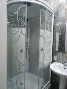 een douche met een glazen deur naast een wastafel bij Comfortable Apartment in Tasjkent