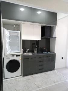 Comfortable Apartment في طشقند: مطبخ مع حوض وغسالة صحون