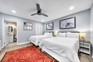 two beds in a bedroom with a ceiling fan at P8G Remodel 2BR/2BA downtown ATL-Parking & Balcony in Atlanta +44 photos