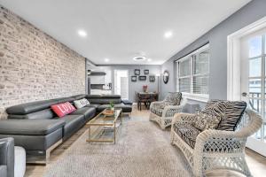 a living room with a couch and chairs and a brick wall at P8G Remodel 2BR/2BA downtown ATL-Parking & Balcony in Atlanta