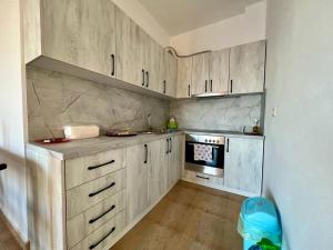 a kitchen with wooden cabinets and a stove top oven at Beach Home Retreat in Durrës