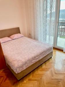 a bed in a bedroom with a large window at VILA MARTINA in Herceg-Novi