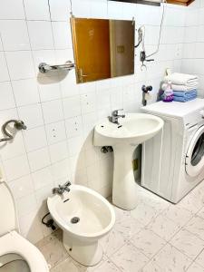 a bathroom with a toilet sink and a washing machine at VILA MARTINA in Herceg-Novi