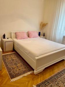 a large white bed with pink pillows in a bedroom at VILA MARTINA in Herceg-Novi