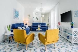 - un salon avec un canapé bleu et deux chaises dans l'établissement Villa Kalu' with pool for up to 16 People, à Nerano