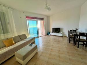 a living room with a couch and a table at Beach Home Retreat in Durrës +2 photos
