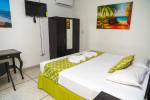 a bedroom with a bed and a desk and a table at Suites & Apartments San Benito - Zona Rosa in San Salvador