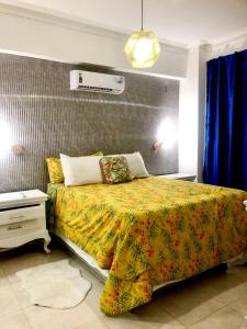 a bedroom with a large bed with a yellow blanket at santo domingo-avenida de españa in Santo Domingo