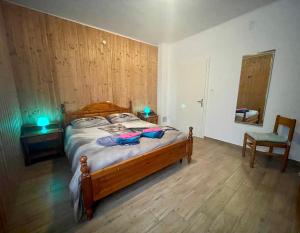 a bedroom with a wooden bed and a chair at Maggioni Silvia in Tarvisio