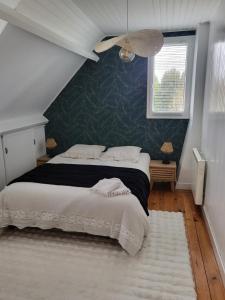 een slaapkamer met een bed met een groene muur bij Vers la crique de Bot-Conan in Fouesnant