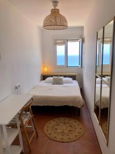 a bedroom with a bed and a desk and a mirror at Apartamento de Carboneras - Terrazas y Vistas in Carboneras