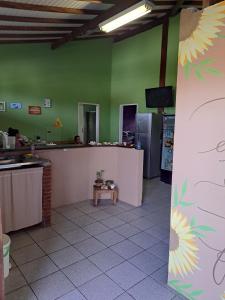 a kitchen with a counter and a person in a room at Girassol Hostel by Katita in Paraty