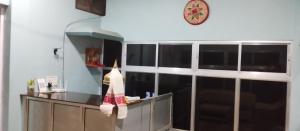 a kitchen with a counter and a clock on the wall at MONIRAMS INN. in Kāziranga