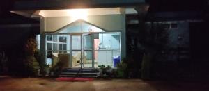a house with a large window in the night at MONIRAMS INN. in Kāziranga +6 photos