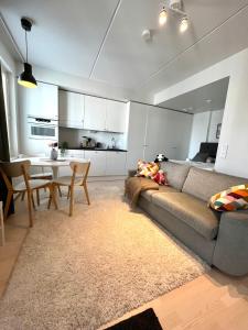 una sala de estar con un sofá y una mesa en Airport brand new 1BR apartment fully equipped, en Vantaa
