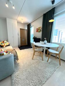 una sala de estar con una mesa y un sofá en Airport brand new 1BR apartment fully equipped, en Vantaa