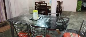 stół z krzesłami i świecą w obiekcie MONIRAMS INN. w mieście Kaziranga