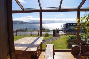 um quarto com uma mesa e vista para a água em Hostal Mundo Nuevo em Ancud