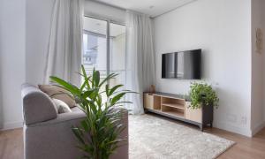 uma sala de estar com um sofá e uma televisão em Tabas - Saint Charbel em São Paulo