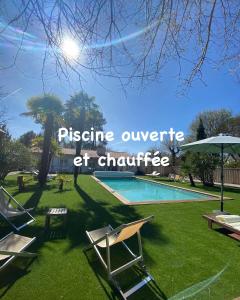 - une piscine avec des chaises longues et un parasol dans l'établissement Villa Herbert, Chambres d'Hôtes et Gîte, à Andernos-les-Bains