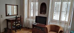 a living room with a tv and a chair and a desk at Garsoniera Central Sibiu in Sibiu