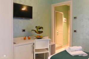 a room with a white counter and a television on the wall at Hotel Riviera Azzurra in Oliveri