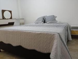 a bed with a blanket and a pillow on it at Habitación Privada y Confortable cerca a Centro Mayor y al Centro Histórico in Bogotá