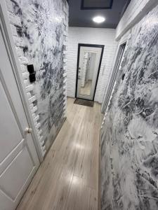un couloir avec un mur en briques blanches et une porte dans l'établissement 1-комнатная квартира Виноградова 12, à Öskemen