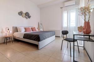 a bedroom with a bed and a table and a guitar at Match Point Apartment, Corfu Town in Ágios Rókkos