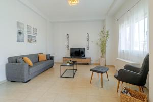 a living room with a couch and a tv at Match Point Apartment, Corfu Town in Agios Rokkos