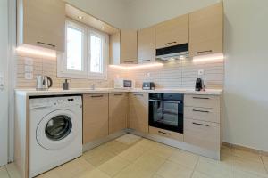 a kitchen with a washing machine and a washer at Match Point Apartment, Corfu Town in Agios Rokkos