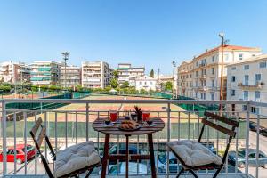 a table on a balcony with a view of a city at Match Point Apartment, Corfu Town in Agios Rokkos