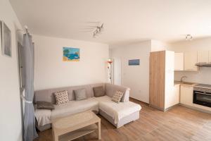 a living room with a couch and a kitchen at Pave&Ema apartman in Konjevrate