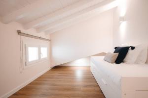 Cette chambre blanche dispose d'un lit et d'une fenêtre. dans l'établissement Alojamento Porta14.4, à Chaves