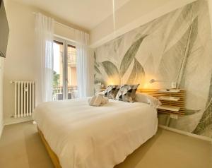 1 dormitorio con 1 cama blanca grande y una pintura en la pared en CasaViva - Central Wonderful Home in Santa M., en Santa Margherita Ligure