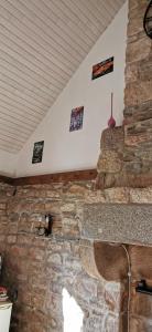 a stone wall in a room with a ceiling at Cottage LE NID in Perriers-en-Beauficel