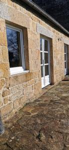 um edifício de tijolos com duas janelas do lado em Cottage LE NID em Perriers-en-Beauficel